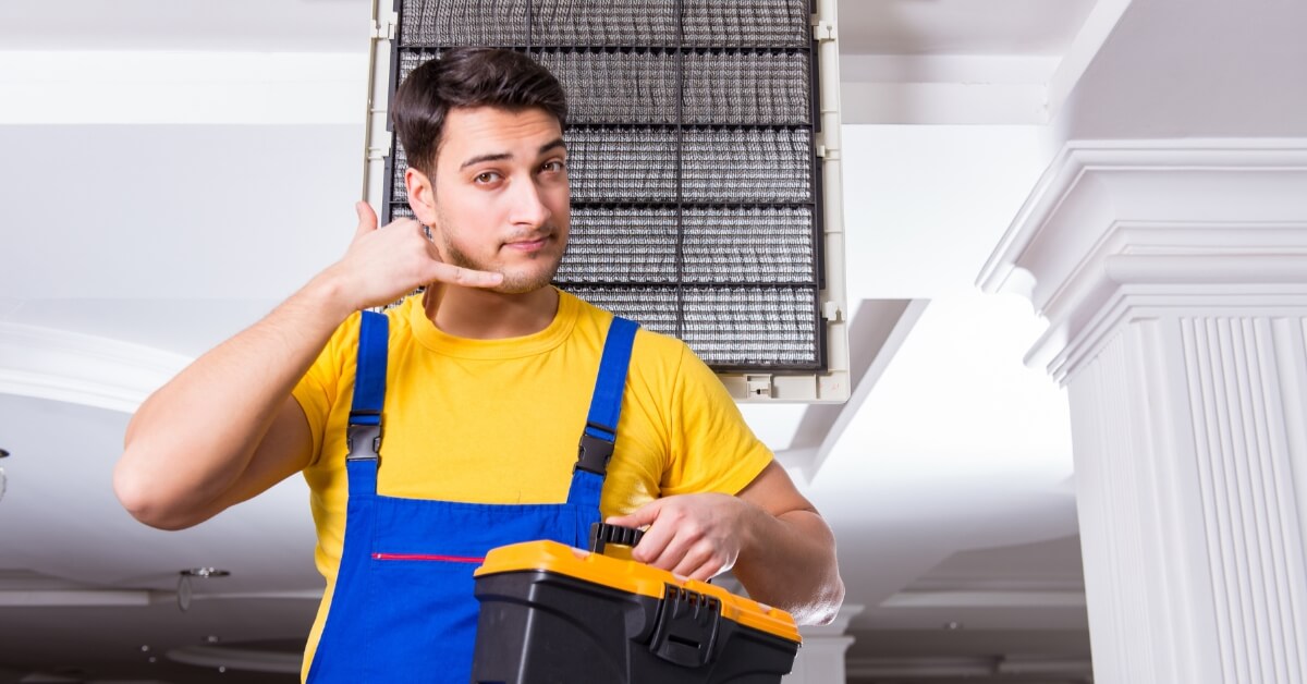 10 Tips for Choosing an HVAC Contractor 1 Man Repairing Air Conditioning unit & showing telephone gesture