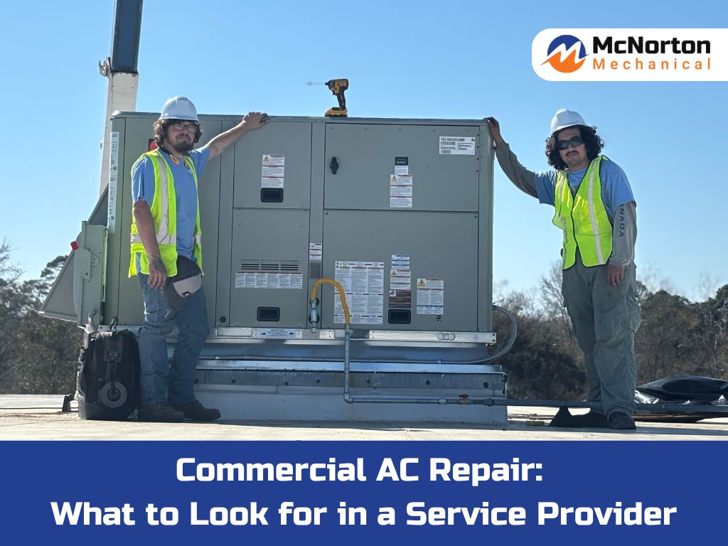 Commercial HVAC technicians standing on a rooftop beside a large AC unit during service work.