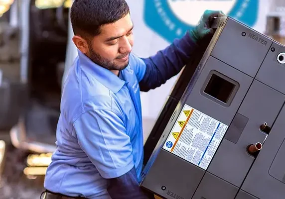 A professional HVAC technician carefully unloads a new American Standard air handler from a service van for a new installation.